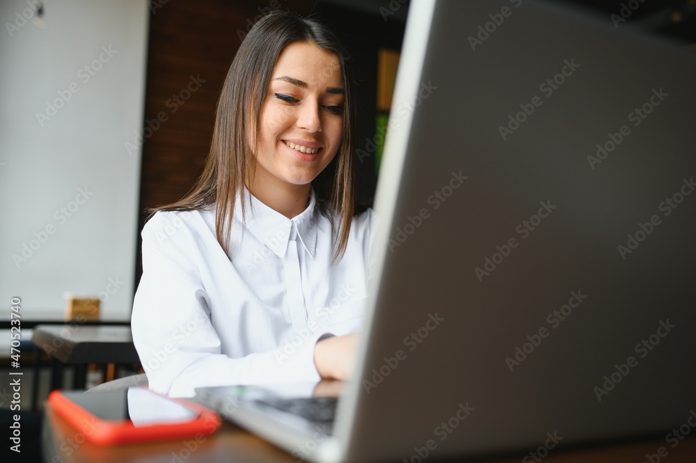 Photo portrait of gorgeous attractive woman working on laptop typing sitting in cafe drinking coffee Photo portrait of gorgeous attractive woman working on laptop typing sitting in cafe drinking coffee
