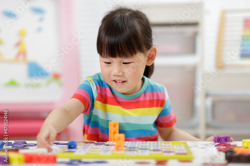young girl play number blocks for home schooling