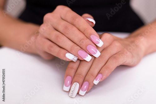 Beautiful female hands with luxury french manicure nails on white background