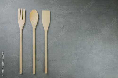 Wooden cutlery on gray background.