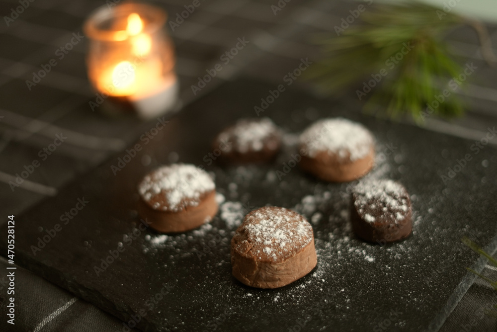Variety of mantecados mantecados, polvorones, nevaditos on the plate decorated with a white fir tree and lights in the background. Typical sweets that are consumed at Christmas time in Spain. Variety of mantecados mantecados, polvorones, nevaditos on the plate decorated with a white fir tree and lights in the background. Typical sweets that are consumed at Christmas time in Spain.