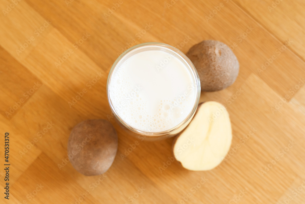 Potato milk photo on wooden background. Glass of alternative milk. Plant based vegetarian beverage. Lactose free drink Potato milk photo on wooden background. Glass of alternative milk. Plant based vegetarian beverage. Lactose free drink