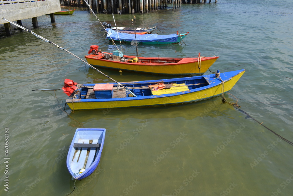four multicolored boats on the coast of the Seam Bay in Thailand