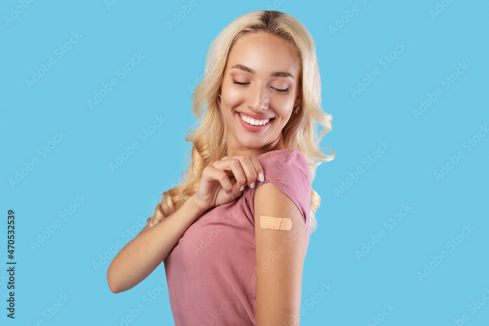 Happy Vaccinated Woman Looking At Shoulder With Adhesive Bandage Happy Vaccinated Woman Looking At Shoulder With Adhesive Bandage