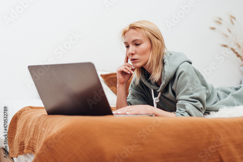 Woman Lying On Lounge Sofa Using Laptop.