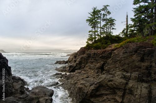 Sunset view of the Pacific ocean during a Fall day from the rocks in Cox Bay in Tofino, Vancouver Island, British Columbia, Canada