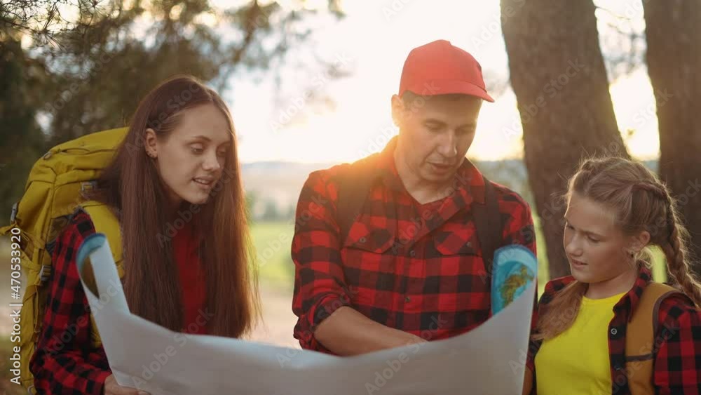 group of tourists hiker with a map. happy family with backpacks travel. adventure kid dream concept. happy lifestyle family hiker in forest park with backpacks looking for path on paper map group of tourists hiker with a map. happy family with backpacks travel. adventure kid dream concept. happy lifestyle family hiker in forest park with backpacks looking for path on paper map