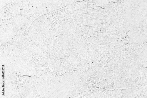 The walls of the cement building are painted white with a rough surface