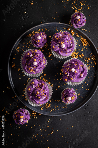 Sweet cupcakes with flower shaped purple cream.