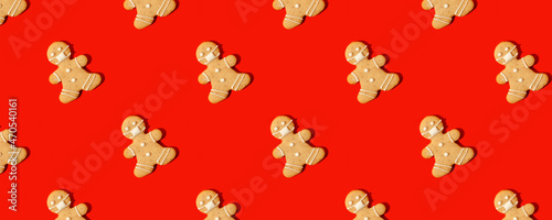 Happy New Year\'s 2022 banner gingerbread man in face mask from ginger biscuits on classic traditional red background, minimal seasonal pandemic winter holiday invitation, seamless pattern