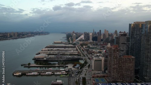 Aerial view of piers and skyscrapers in Hell's Kitchen, Manhattan, cloudy evening in New York - pan, drone shot
