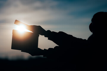 Silhouette of Hands Holding a Film Slate in the Sunset