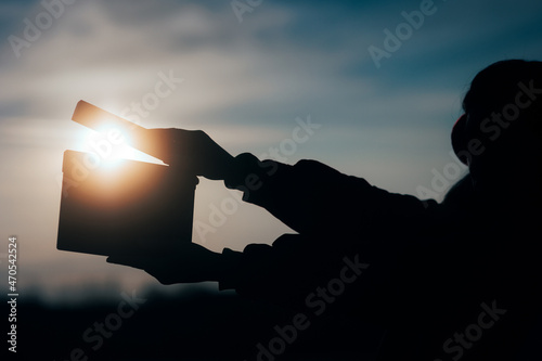 Silhouette of Hands Holding a Film Slate in the Sunset photo