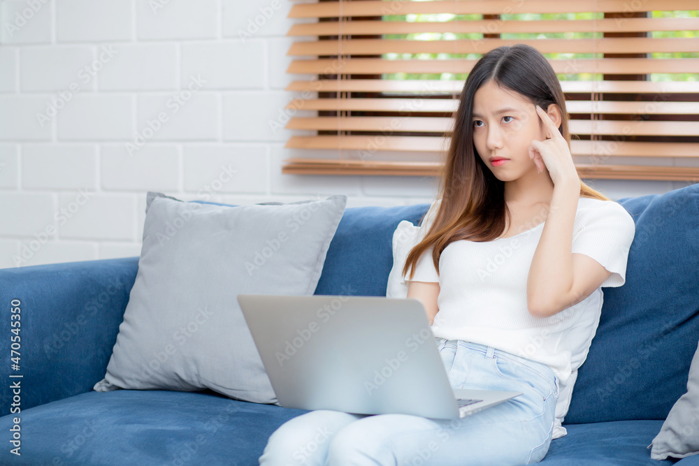 Young asian woman work on laptop computer on sofa at home with frustrated and bored, freelance girl unhappy and tired with unsuccessful, upset from problem, failure and mistake, business concept. Young asian woman work on laptop computer on sofa at home with frustrated and bored, freelance girl unhappy and tired with unsuccessful, upset from problem, failure and mistake, business concept.