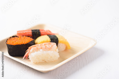 Nigiri sushi in a plate made from tree leaf on a white background is a cultural food of Japan, Asia.