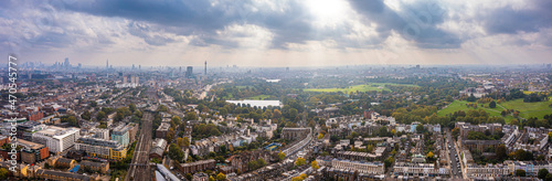 Beautiful aerial view of London with many green parks and city skyscrapers in the foreground. © Aerial Film Studio