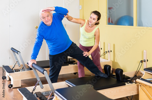 Senior man workout in rehabilitation center. Personal trainer helping senior man © JackF