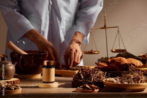 Traditional chinese medicine with herb and spices in brown wooden background and a doctor for advertising , chinese traditional medicine content 