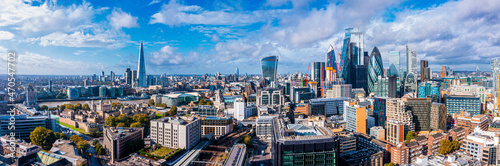 Aerial panoramic scene of the London city financial district with many iconic skyscrapers near river Thames.