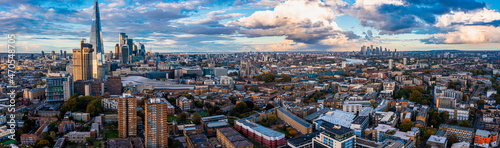 Aerial panorama of the London city financial district with many iconic skyscrapers near river Thames at sunset.