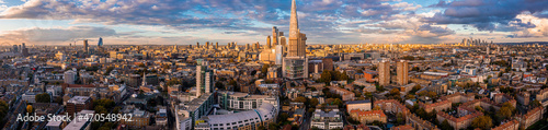 Aerial panorama of the London city financial district with many iconic skyscrapers near river Thames at sunset.