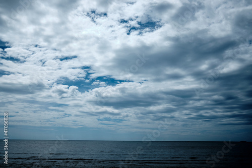 Beautiful seascape with white clouds and blue sky. Ocean or sea on horizon. Summer vacation or travel concept. Leisure time nature background with copy space. Beautiful seascape with blue sky