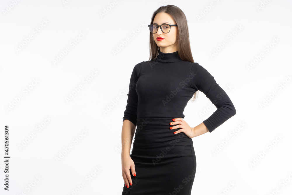 Business woman on white. Studio portrait of woman in strict dress. Girl is dressed in black dress. Businesswoman keeps her hand on her side. Young girl isolated. Business lady with glasses Business woman on white. Studio portrait of woman in strict dress. Girl is dressed in black dress. Businesswoman keeps her hand on her side. Young girl isolated. Business lady with glasses
