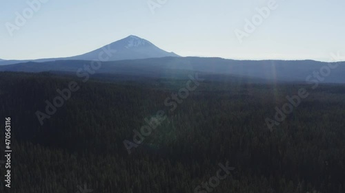 flying over pine forest on bright sunny day with Mount McLoughlin on background. Oregon, USA photo