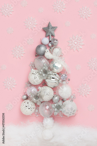 Creative Christmas tree made from xmas baubles  decor in flat style on pink background. Merry Christmas and Happy New Year concept. Top view  Flat lay. Greeting card