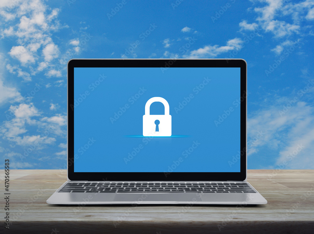 Padlock flat icon on modern laptop computer monitor screen on wooden table over blue sky with white clouds, Technology internet cyber security and safety online concept Padlock flat icon on modern laptop computer monitor screen on wooden table over blue sky with white clouds, Technology internet cyber security and safety online concept