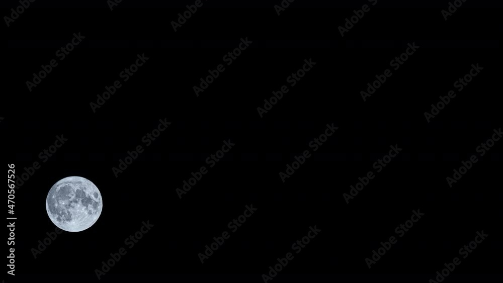 bright full moon rising in the sky, black background at night. timelapse bright full moon rising in the sky, black background at night. timelapse