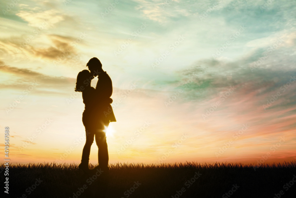 Silhouette of young couple kissing and embracing