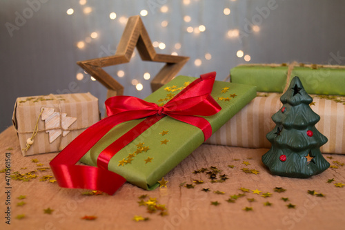 Christmas gifts in green and brown kravtovoy packaging with red ribbon. Gift wrapping. Waiting for the holiday. Christmas shopping