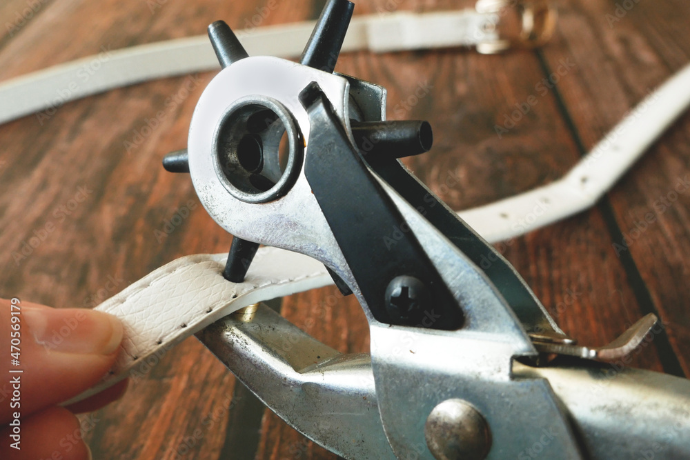 The process of manufacturing a leather belt by tanner. Puncture holes