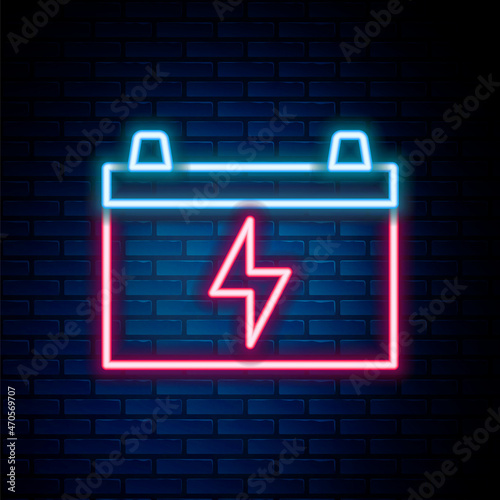 Glowing neon line Car battery icon isolated on brick wall background. Accumulator battery energy power and electricity accumulator battery. Colorful outline concept. Vector