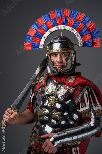 Antique pensive legionary posing against gray studio background