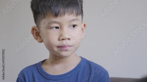 Asian boy with hyperactive kid syndrome or ADHD. A 5 years old kid keep moving his body while stand still. photo