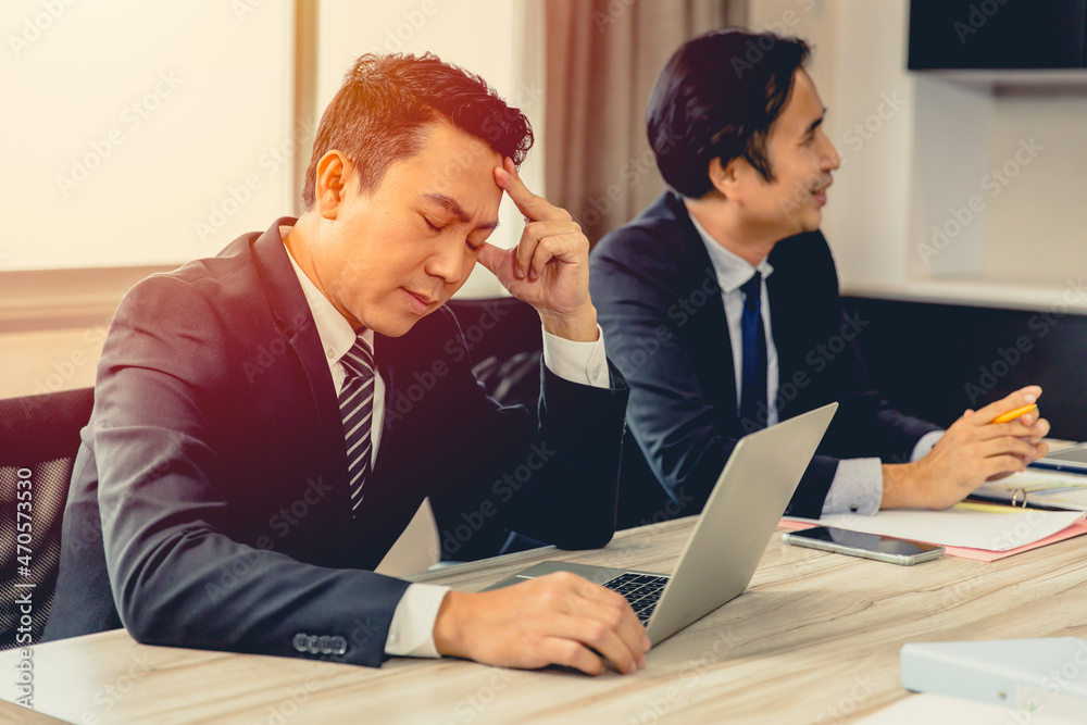 Businessman feel Tired Exhausted Headache with happy friend in business meeting room. Businessman feel Tired Exhausted Headache with happy friend in business meeting room.