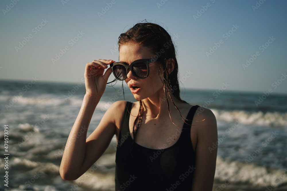 woman in black swimsuit walking on the beach ocean summer