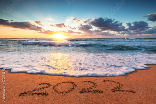 Happy New Year 2022 concept, lettering on the beach. Written text on the sand.