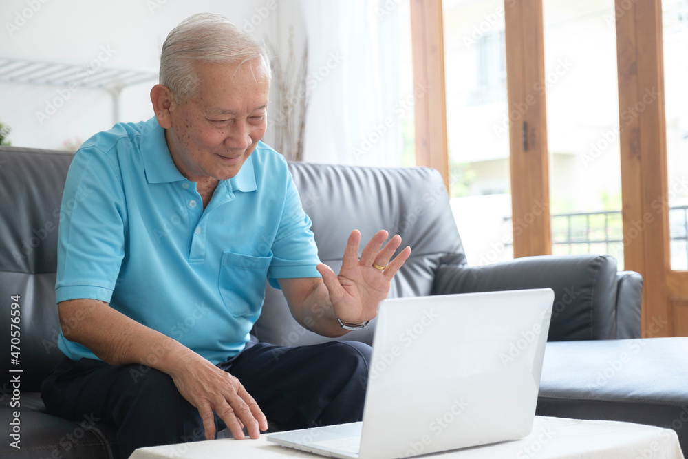 Elderly man making video call and waving at screen. Elderly man making video call and waving at screen.
