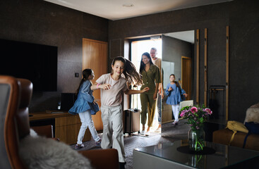Happy young family with two children enetring room at luxury hotel, summer holiday.