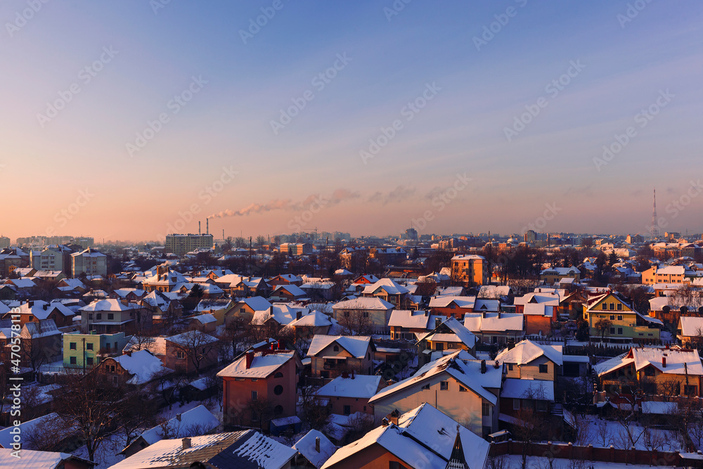Winter cityscape. Winter City Top View Sunrise. City panorama with smokestack chimney and smoke coming out of it
