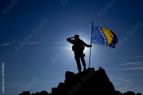 Silhouette of an unrecognizable soldier with the Bosnian flag