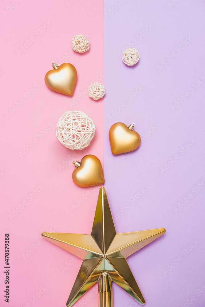 Christmas tree toys in the shape of a golden star, balls and hearts on pink and violet background. Xmas and New Year celebrating party. Flat lay, minimalism
