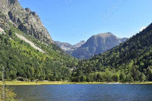 Beautiful mountains blue lake green valley forest.Bright breathtaking thrilling view at Pyrenees Europe.Aiguestortes national park Spain. in summer sunny weather.Copy space
