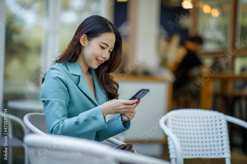 Young businesswoman using a smartphone in a coffee shop, Outdoor.