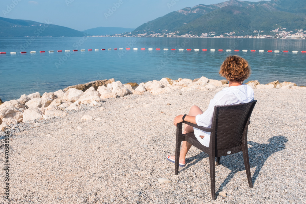 Fototapeta premium Woman relaxing on a beach chair. Vacation and holidays concept. Tivat, Montenegro