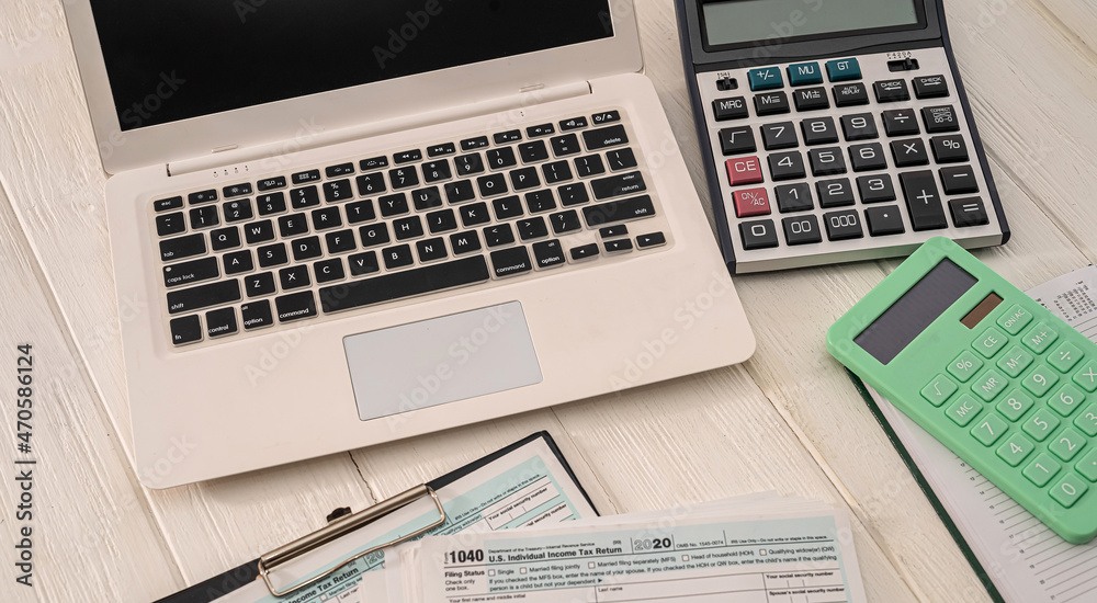 new laptop two calculators and blank blank tax form usa 1040 with tablet lying on the table new laptop two calculators and blank blank tax form usa 1040 with tablet lying on the table