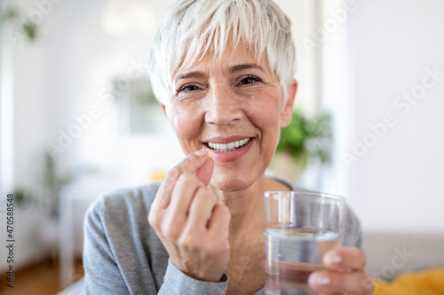 Fotografia, Obraz Head shot portrait happy woman holds pill glass of water, takes daily medicine v